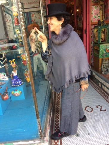 Gray sweater poncho with faux fur collar by SHIHREEN, $70.  Black and white striped pant by TULIP, $79. Black top hat by JSA, $69